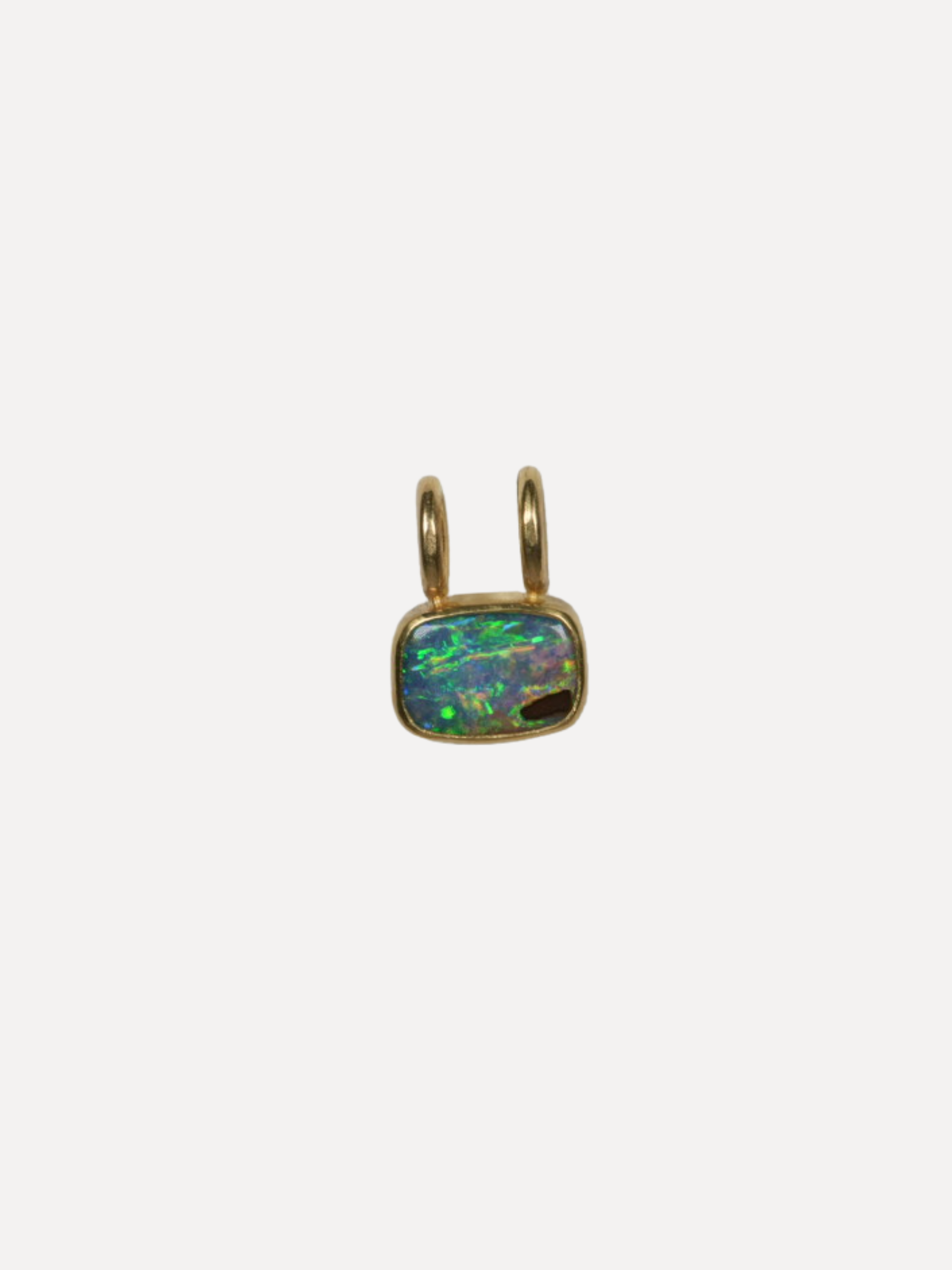 Gold pendant with an opal stone on a white background