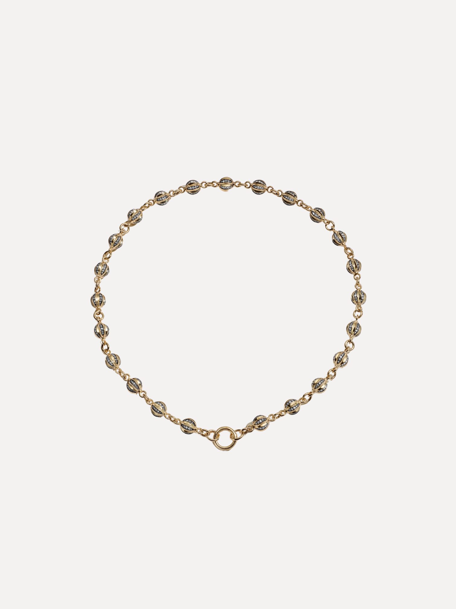 Gold bracelet with small beads on a light beige background