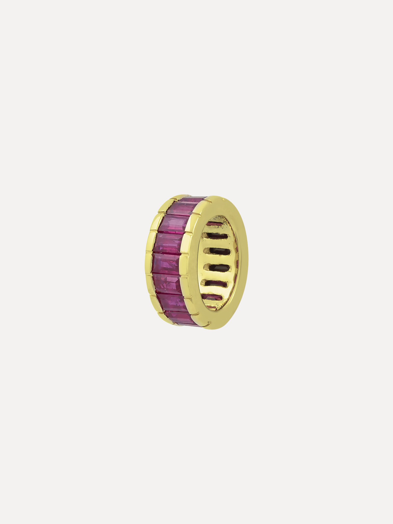 Gold ring with purple gemstone on a light gray background
