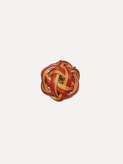 Red and gold woven ball on a white background. Bamboo ring with pink sapphire ring