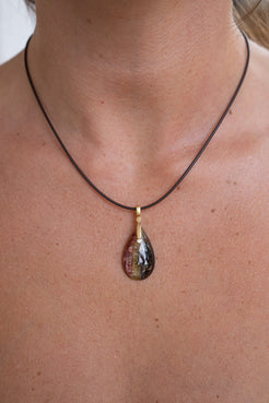 Necklace with a teardrop-shaped pendant on a person's neck
