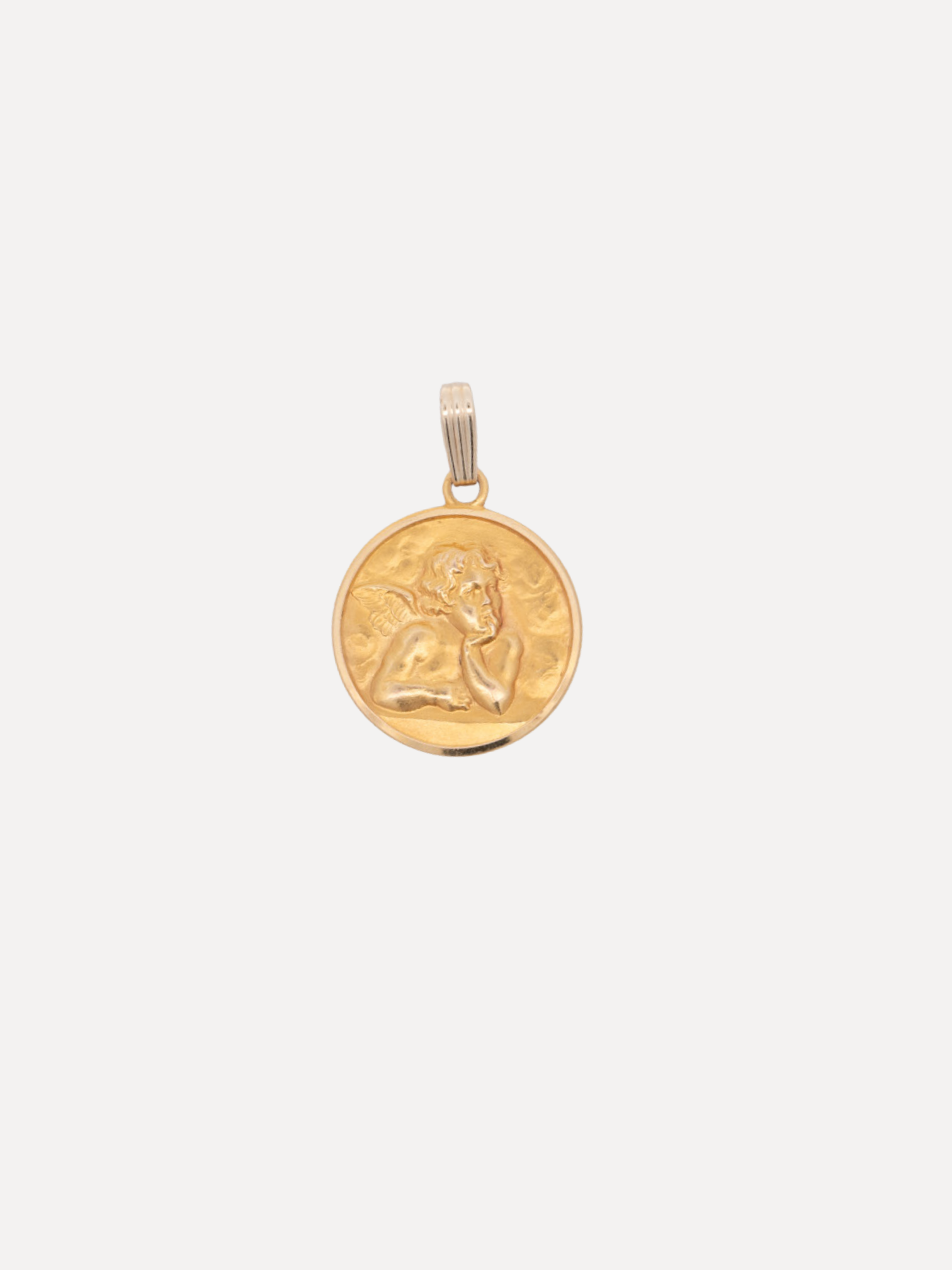 Gold pendant with a face design on a white background
