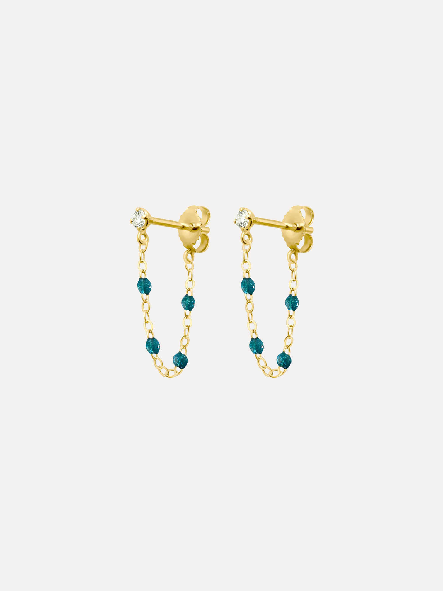 Gold earrings with teal beads on a white background