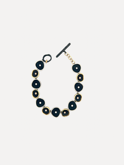 Black and gold bracelet on a light gray background