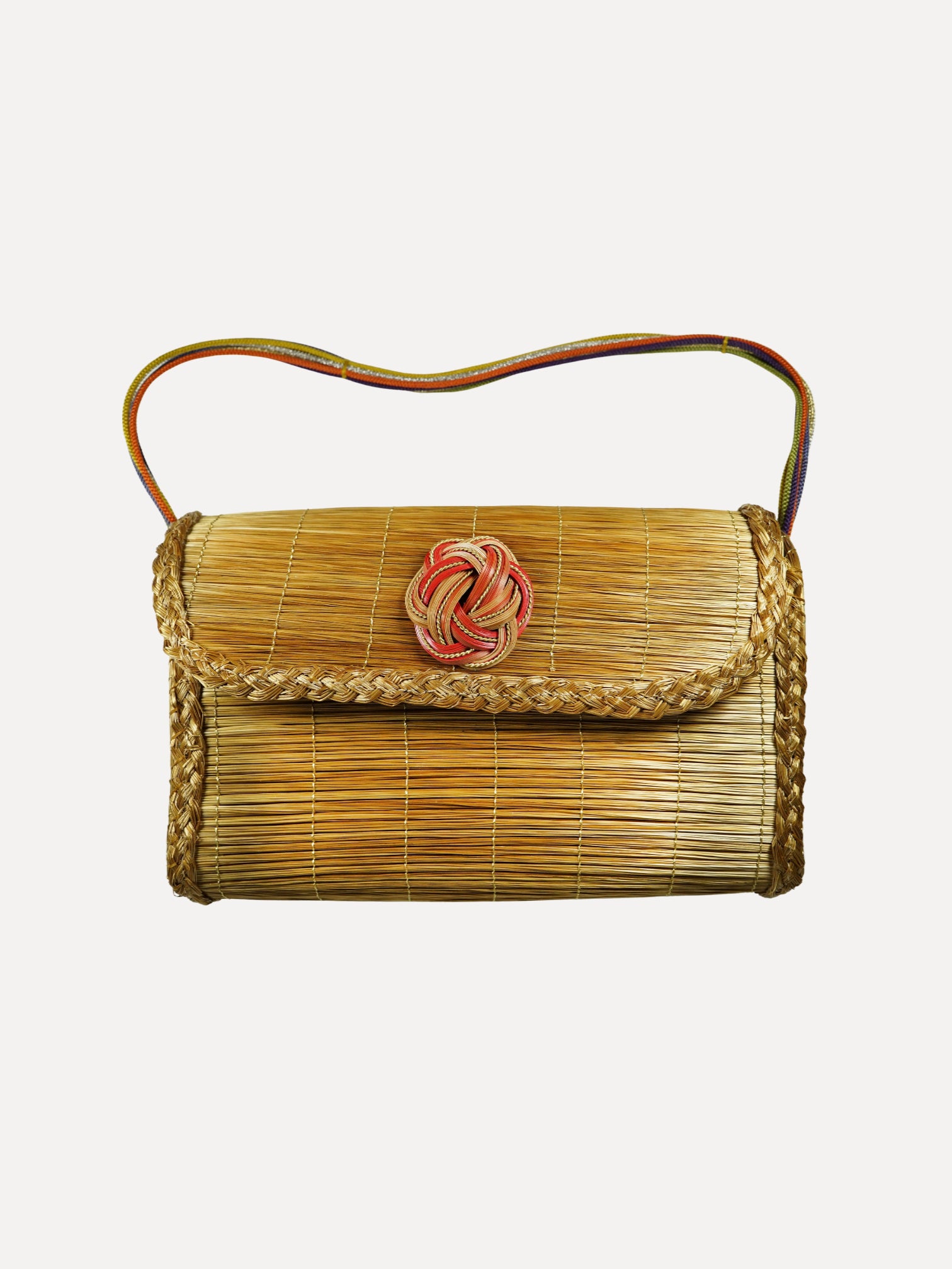 Woven handbag with a decorative clasp on a white background