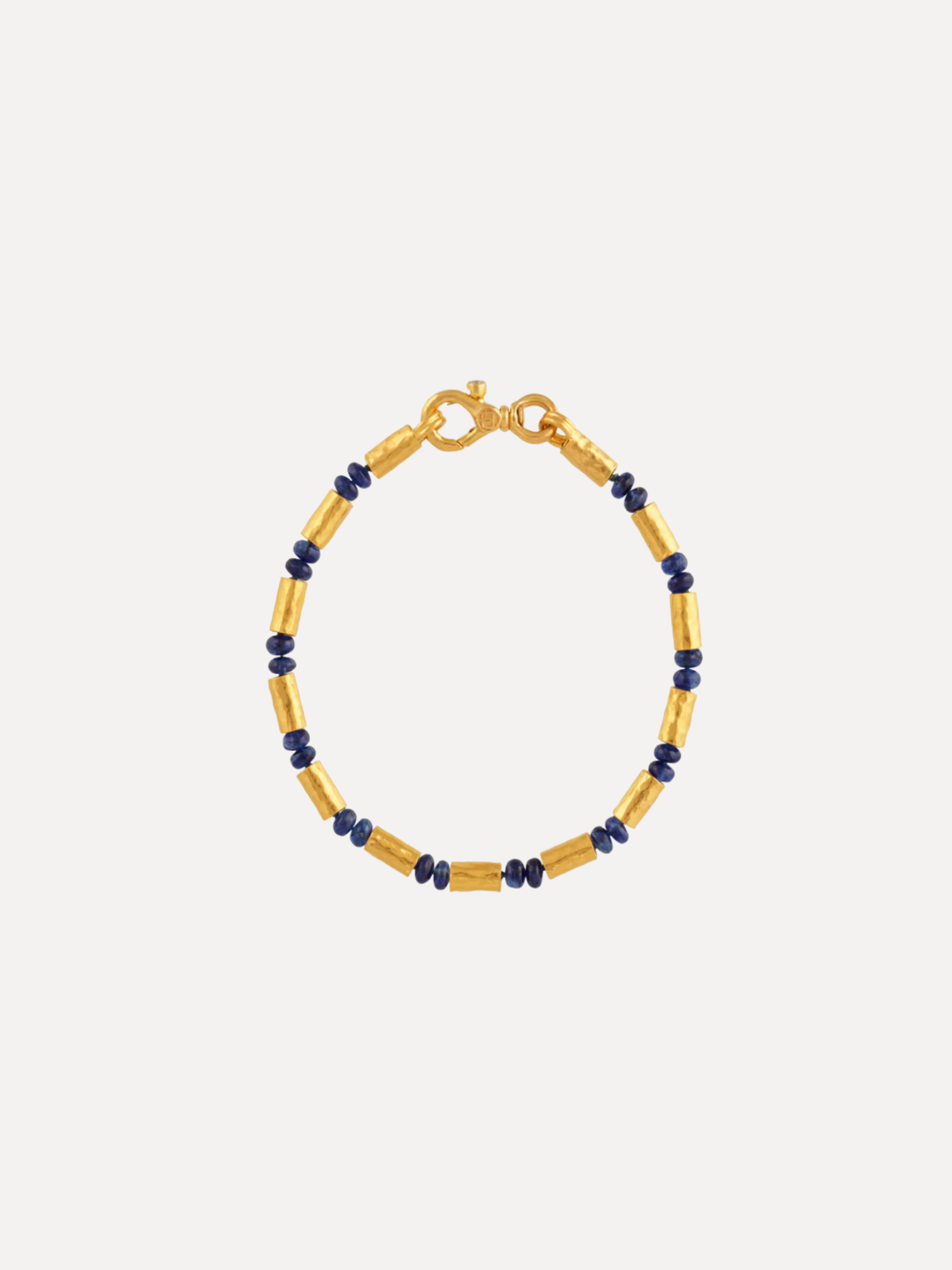 Gold bracelet with blue beads on a white background