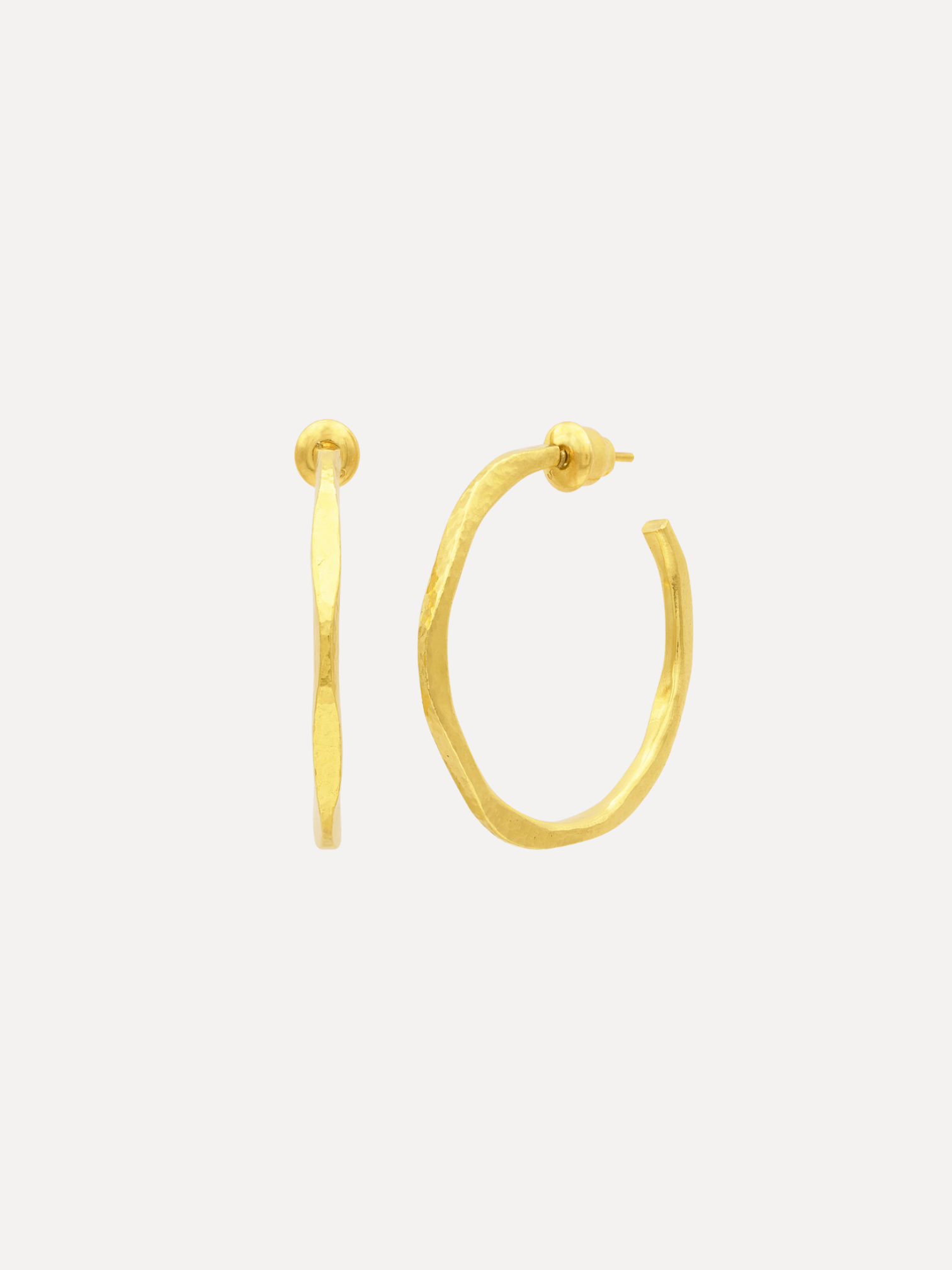 Gold hoop earrings on a light beige background
