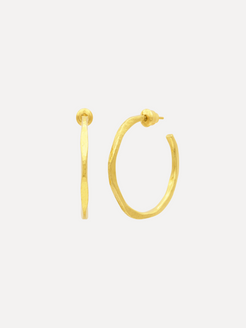 Gold hoop earrings on a light beige background