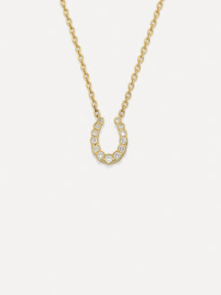 Gold necklace with a horseshoe-shaped pendant on a white background