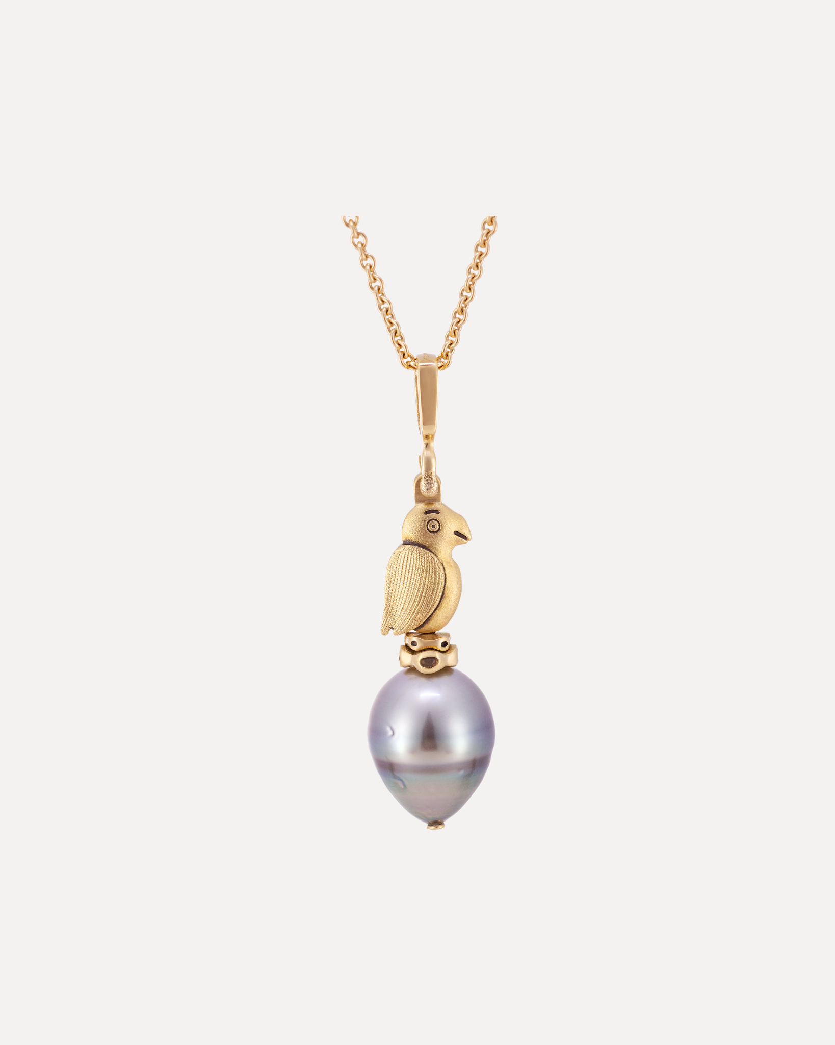 An 18k yellow gold pearl puffin pendant on a gold chain by Alex Sepkus.