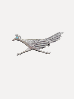 Silver bird-shaped brooch with a turquoise stone on a white background