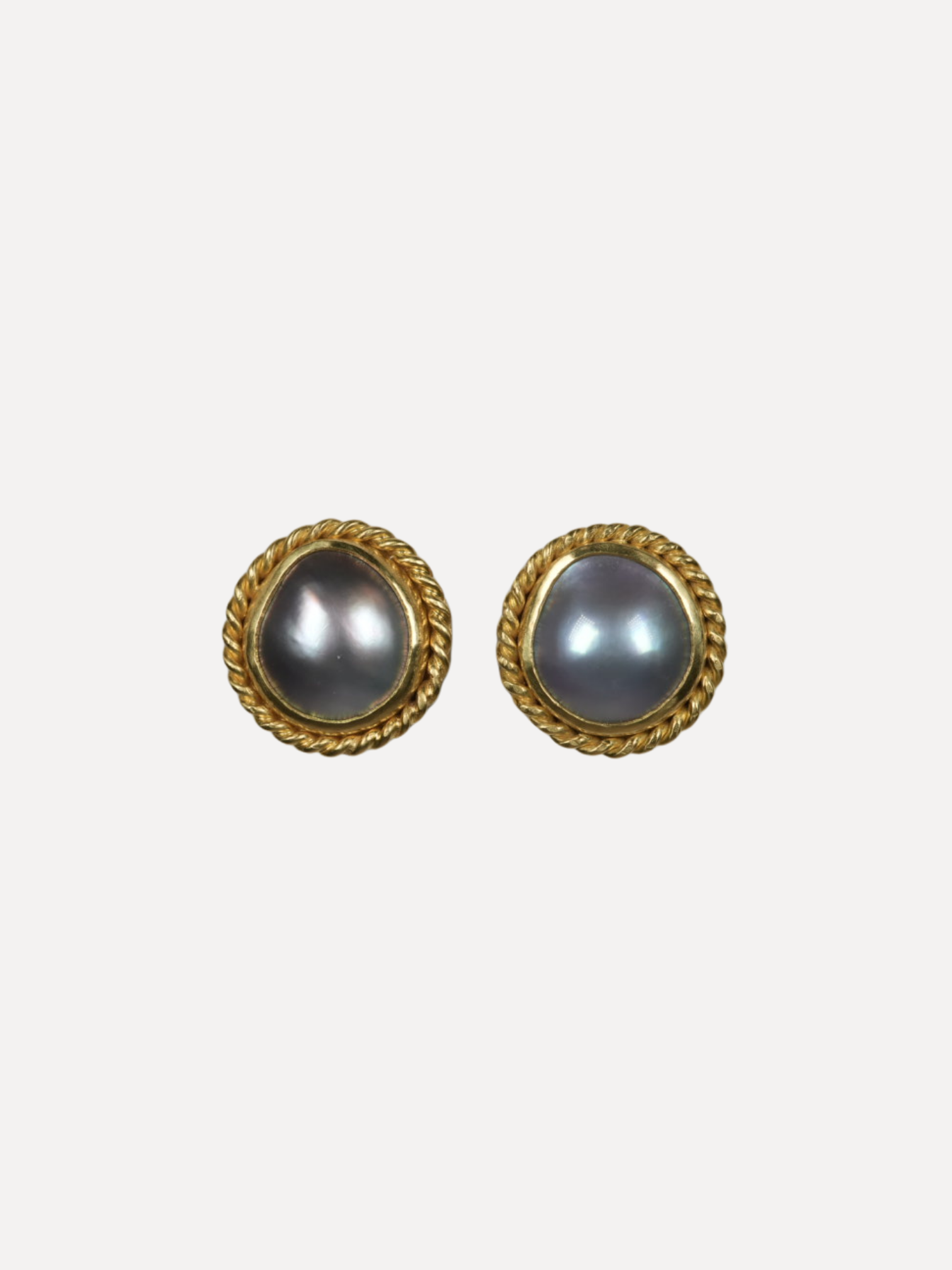 Pair of gold-framed earrings with gray pearls on a white background