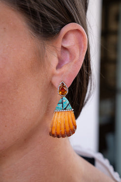 Close-up of a woman's ear wearing an orange and turquoise earring. Silvia_Furmanovich_Shell_Earrings