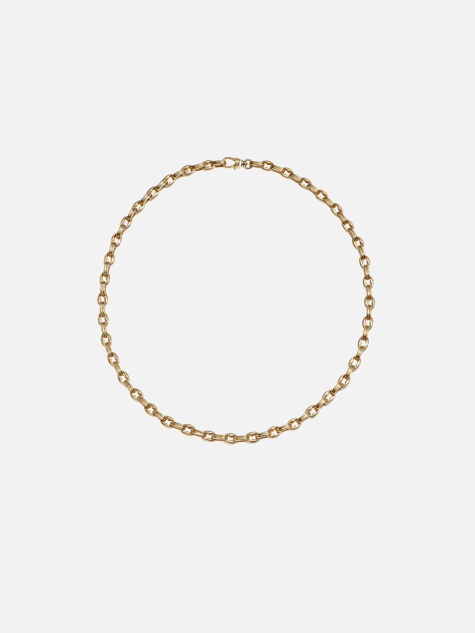 Gold chain necklace on a light beige background