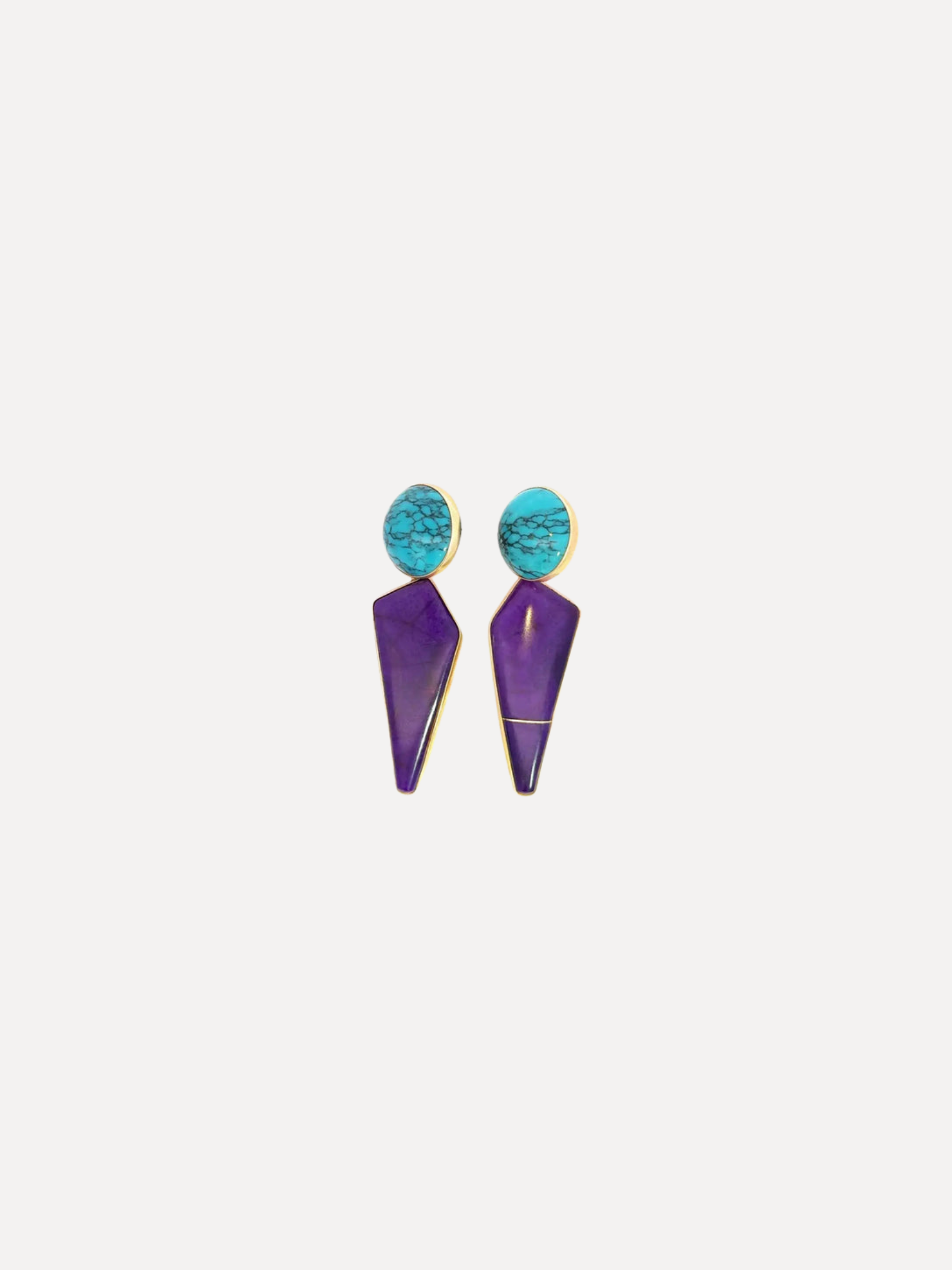 A pair of statement dangle earrings featuring textured turquoise blue oval studs and long, faceted purple drop pendants with gold-tone metal borders, set against a solid off-white background.
