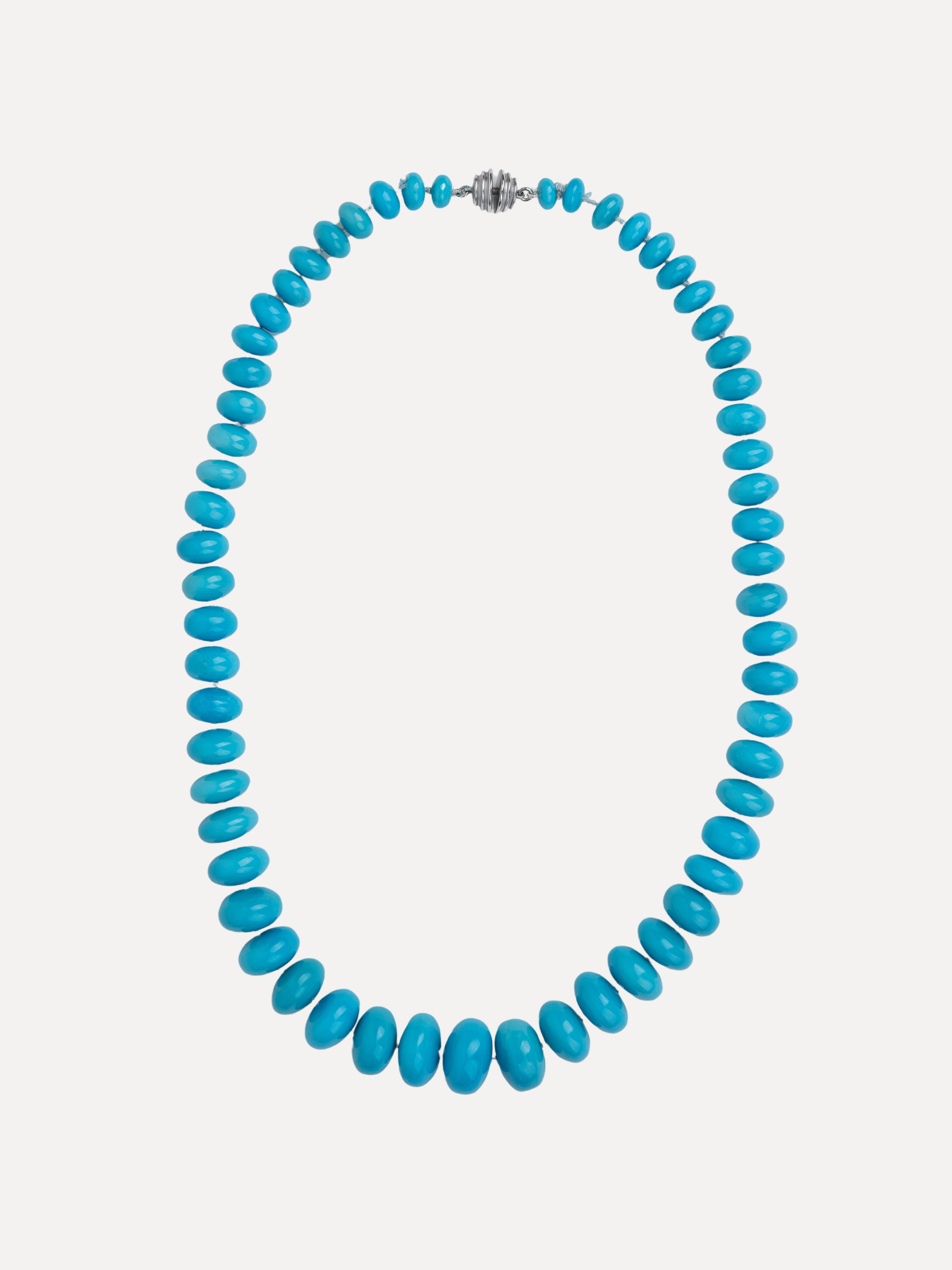 A turquoise beaded necklace with a silver-toned textured clasp, displayed against a light gray background.