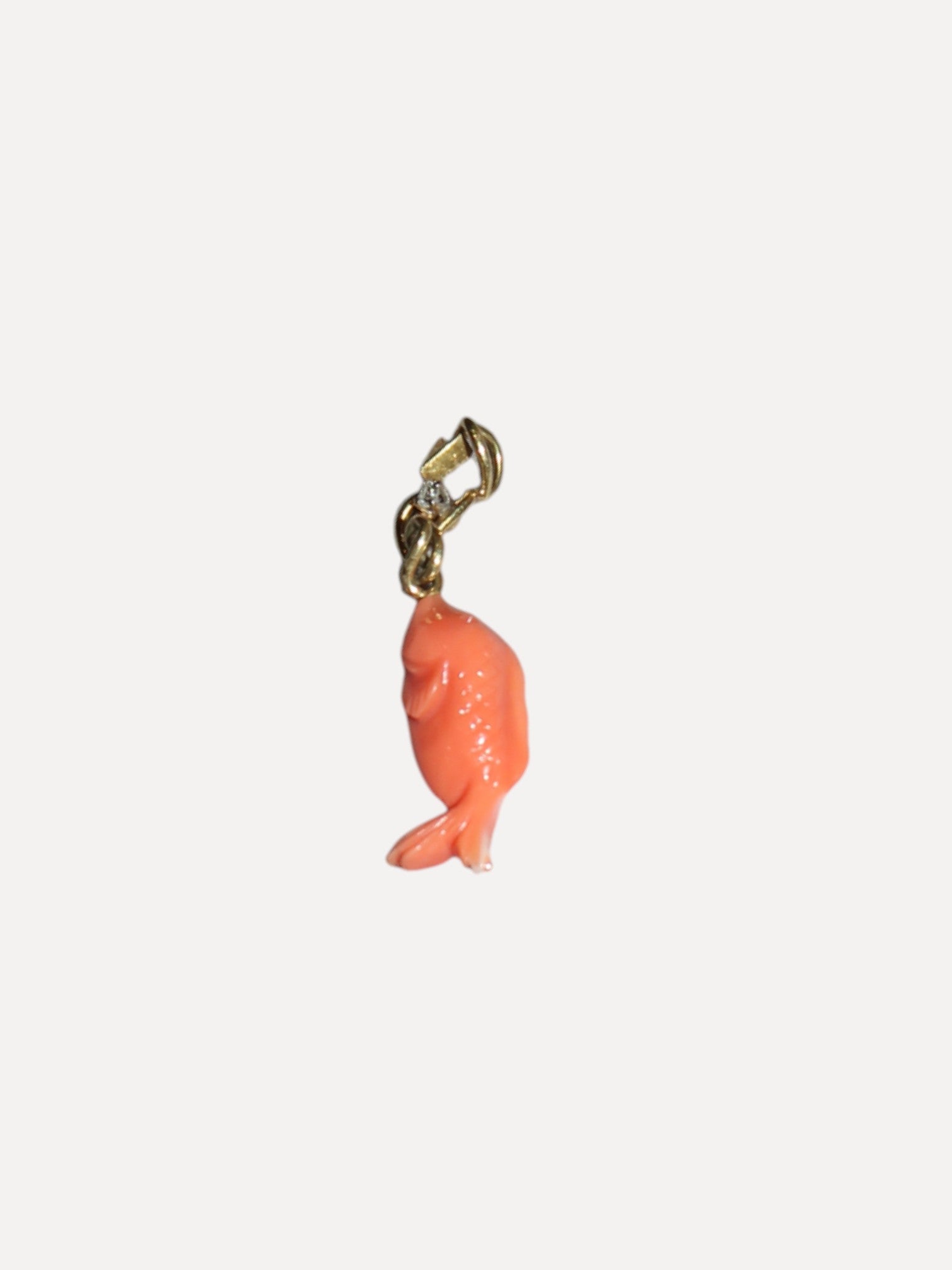 Coral fish charm with gold clasp on a white background