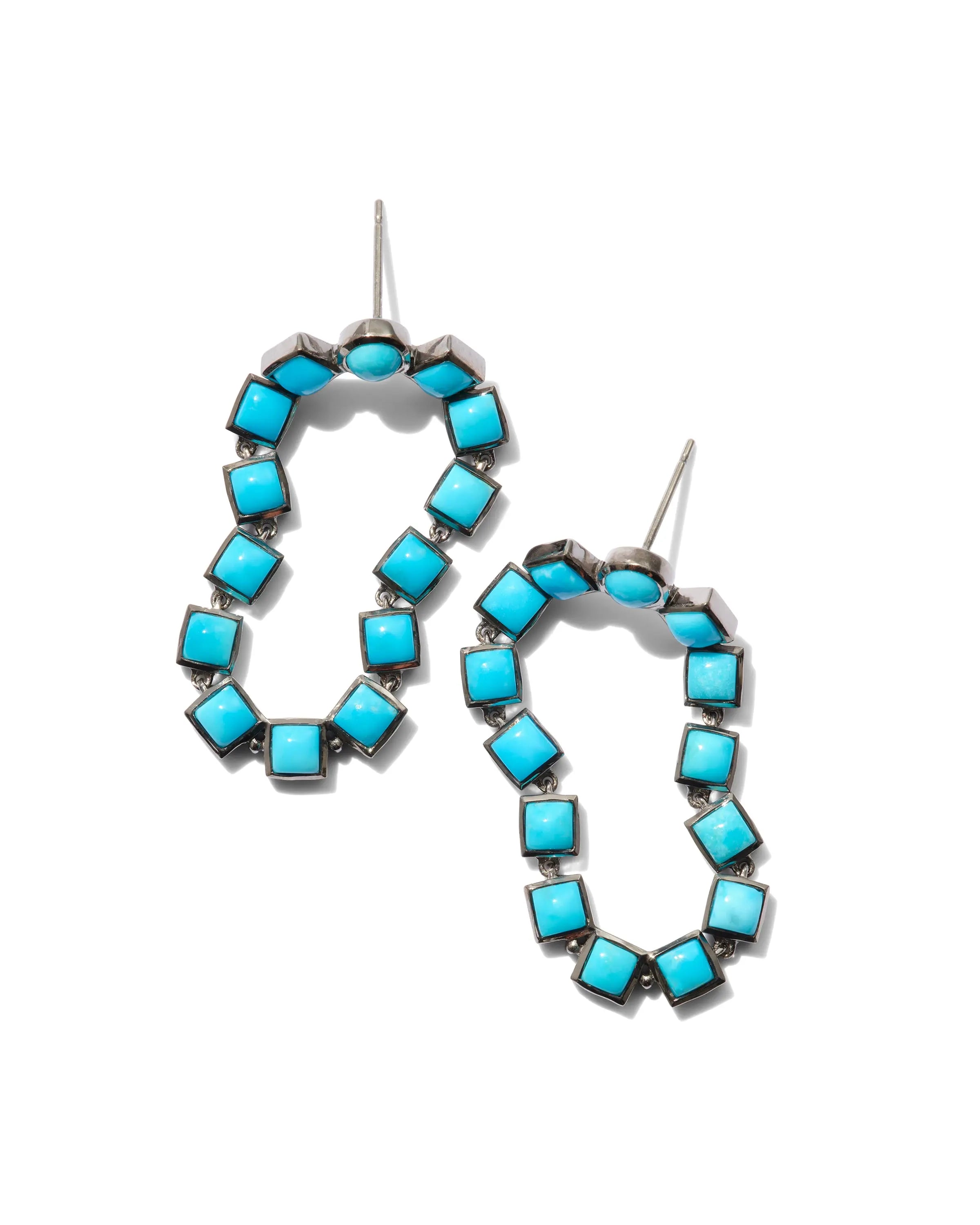 Designed by Nak Armstrong these earrings are so much fun. They are set in sterling silver with a black rhodium finish and turquoise. The turquoise is 3.5mm square turquoise. The length is  1 1/2" in length with post and nut closures.