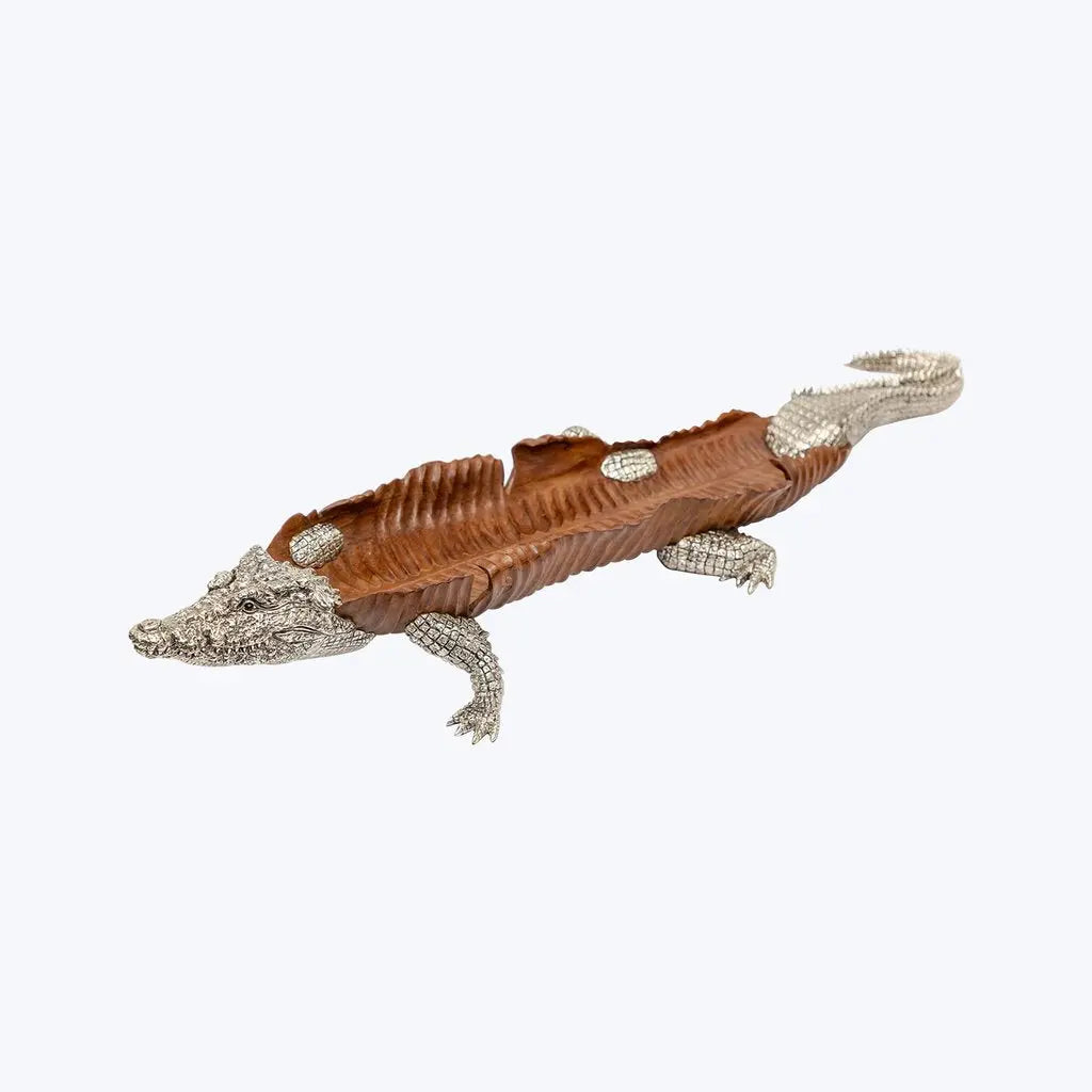 A Crocodile sculpted from a single piece of rare teak wood, eyes set with black Agate, Sterling silver cast head, legs and tail.    This piece can also be an casual dining implement as a large bowl, to serve fruits or to decorate flowers, apart from being a center piece in any luxurious living room.   It took approximately 3 months to produce.  Made by Lotus Arts de Vivre