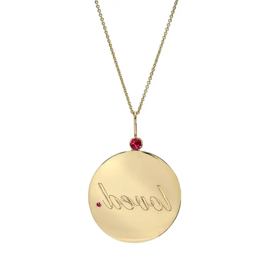 This large 14k medallion is intended to be read in the mirror by the wearer as a reminder. It is the size and shape of a quarter and hangs from a ruby bezel and has a small ruby &quot;period.&quot;  Diameter: 1  Weight: 7 g  CTW: .16  Chain sold separately.  Designed by DRU Jewelry