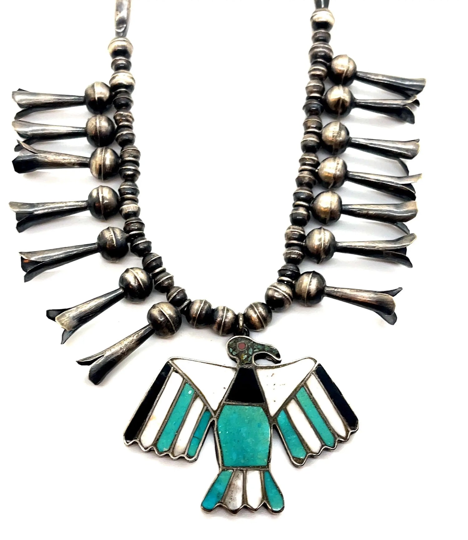 Vintage 1960s Zuni Thunderbird Turquoise Squash Blossom Necklace  Number of flowers 14  Material: Sterling Silver, Turquoise and Mother of Pearl Inlay  Length around the necklace is 22 inches and the Naja is 2.5 inches long  Good Vintage Condition  Note - Please bear in mind that you are purchasing vintage, it might not be perfect but it will be authentic.