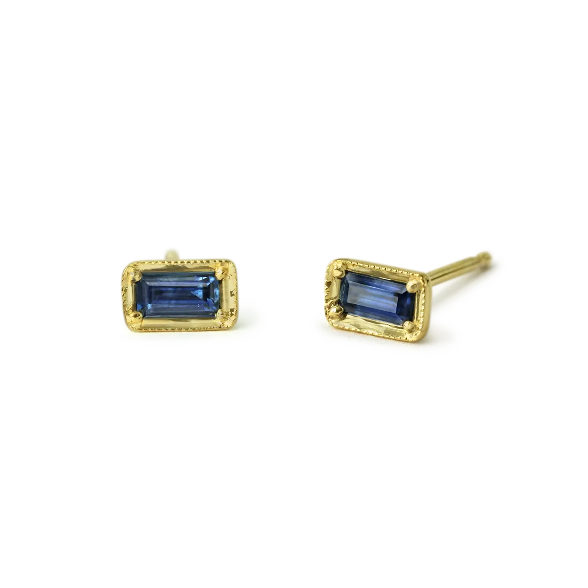 Great Blue Sapphire Stud Earrings in 14k Yellow Gold. The sapphires are .27 cttw baguette blue sapphire  Sold as a pair  Dimensions: 3.5x6.3mm  If an item is out of stock, please allow 3-6 weeks for delivery.  Designed by ILA