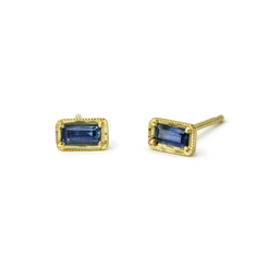 Great Blue Sapphire Stud Earrings in 14k Yellow Gold. The sapphires are .27 cttw baguette blue sapphire  Sold as a pair  Dimensions: 3.5x6.3mm  If an item is out of stock, please allow 3-6 weeks for delivery.  Designed by ILA