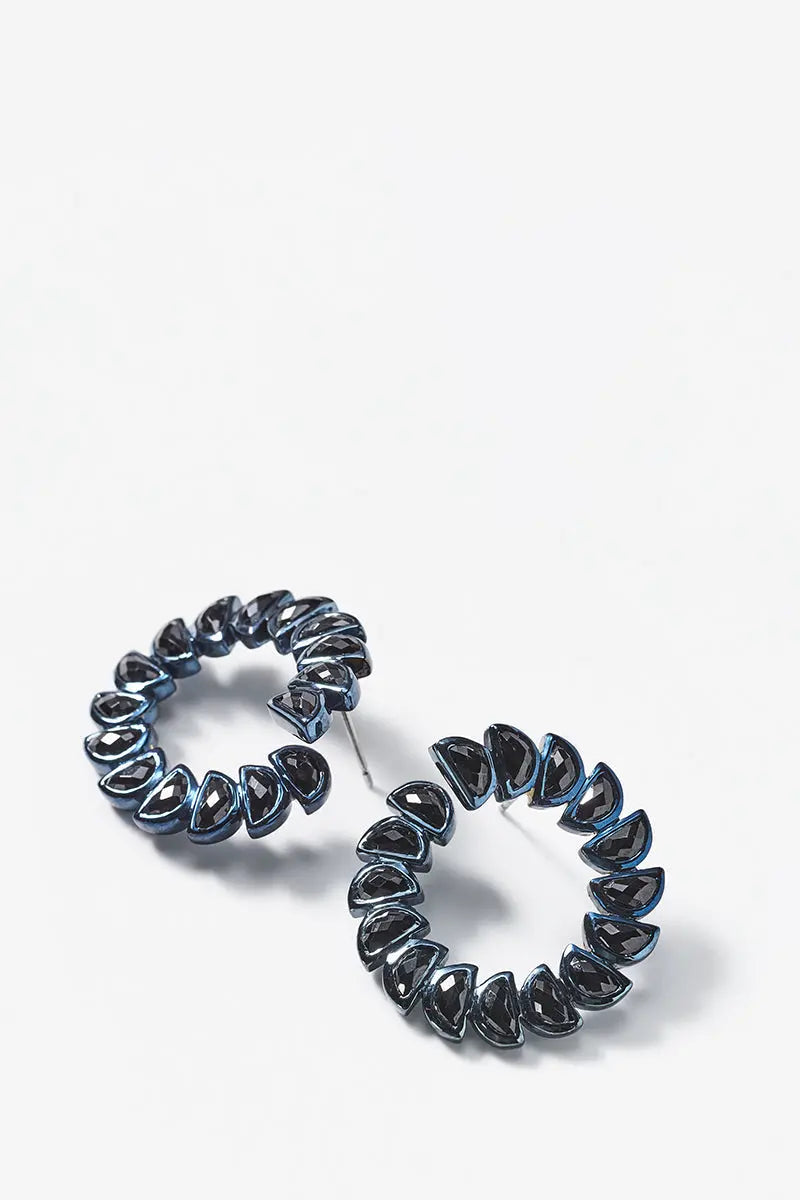 Designed by Nak Armstrong these earrings are so much fun. They are set in sterling silver with a black rhodium finish and black spinel. The black spinel is set with blue rhodium. The  is 3.5mm square turquoise. The length is 1" in diameter. in length with post and nut closures.